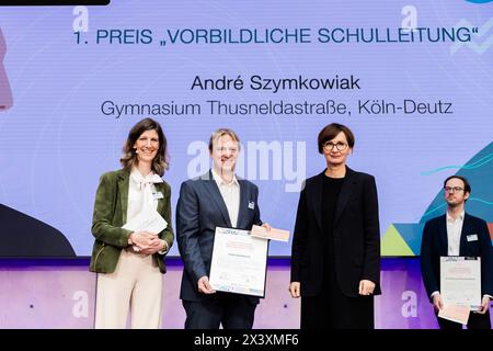 29 April 2024, Berlin: Andre Szymkowiak (M) from Thusneldastrasse Gymnasium in Cologne-Deutz is awarded first prize in the 'Exemplary School Management' category by Bettina Stark-Watzinger (FDP, r), Federal Minister of Education and Research, and Alexandra Heraeus (l), Chairwoman of the Board of the Heraeus Education Foundation, at the 'German Teachers' Award - Innovative Teaching' 2023 ceremony. The competition is sponsored by the German Philological Association and the Heraeus Education Foundation. Ten teachers, three head teachers and five teaching teams from twelve federal states will be h Stock Photo