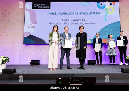 29 April 2024, Berlin: Andre Szymkowiak (M) from Thusneldastrasse Gymnasium in Cologne-Deutz is awarded first prize in the 'Exemplary School Management' category by Bettina Stark-Watzinger (FDP, r), Federal Minister of Education and Research, and Alexandra Heraeus (l), Chairwoman of the Board of the Heraeus Education Foundation, at the 'German Teachers' Award - Innovative Teaching' 2023 ceremony. The competition is sponsored by the German Philological Association and the Heraeus Education Foundation. Ten teachers, three school administrators and five teaching teams from twelve federal states w Stock Photo