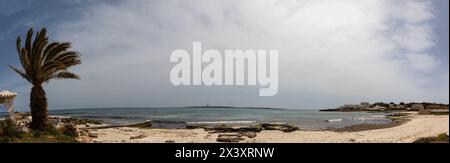 Playa de Punta Prima en Menorca de arena blanca y fina y aguas transparentes. Al fondo la isla del aire con su faro. España Stock Photo