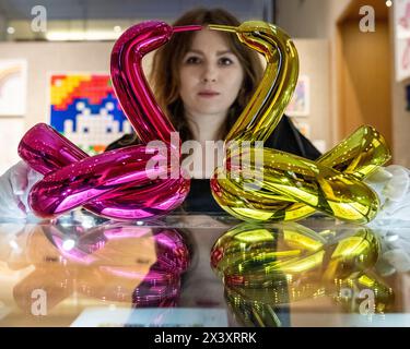 London, UK.  29 April 2024. A staff member with two works from the six 'Balloon Animals Collector's Set', 2017-2019, by Jeff Koons, (Est. £50,000 - £70,000), at the preview of ‘Hot Off The Press’, a sale of prints and new editions, created and published within the last fifty years, by well-known contemporary artists.  The works will be auctioned at Bonhams New Bond Street on 1 May. Credit: Stephen Chung / Alamy Live News Stock Photo