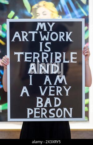 London, UK.  29 April 2024.  A staff member with 'My Artwork is Terrible and I Am a Very Bad Person', 2018, by David Shrigley (Est. £800 - £1,200) at the preview of ‘Hot Off The Press’, a sale of prints and new editions, created and published within the last fifty years, by well-known contemporary artists.  The works will be auctioned at Bonhams New Bond Street on 1 May.  Credit: Stephen Chung / Alamy Live News Stock Photo