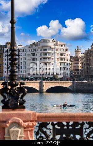 Rowers exercising in the Urumea River, Maria Cristina and Santa Catalina Bridges, Maria Cristina Bridge elegant structure crossing over the River Urum Stock Photo