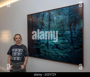 London, UK.  29 April 2024. Artist Joanna Vestey with her work 'From the series: 3Days|2Nights,1830-2030|06.07.23. Borrowdale Woods, Lake District', 2023, at the preview of artworks for ‘AT The Bus’, an exhibition of works donated by leading artists to support charity, offering art as therapy for young people.  The exhibition is open to the public from 29 April to 7 May in Sotheby’s New Bond Street galleries after which the artworks will be offered for sale in an online auction powered by Artsy.  Credit: Stephen Chung / Alamy Live News Stock Photo