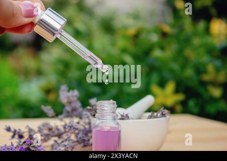 Glass bottle of lavender essential oil on a wooden background Stock Photo