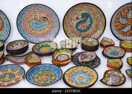 colorful oriental Uzbek ceramic plates hand-painted at souvenir tableware market in Uzbekistan Stock Photo