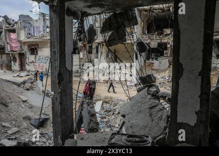 Rafah, Palestinian Territories. 29th Apr, 2024. Palestinians pass by the massive destruction of the house belonging to the Al-Khatib family after the bombing by Israeli warplanes. Credit: Abed Rahim Khatib/dpa/Alamy Live News Stock Photo