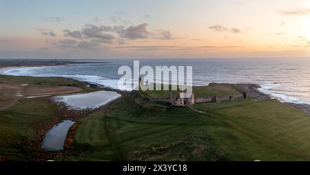 DUNSTANBURGH CASTLE, NORTHUMBERLAND, UK - APRIL 20, 2024.  Aerial landscape panorama view above the medieval ruins of Dunstanburgh castle on the North Stock Photo