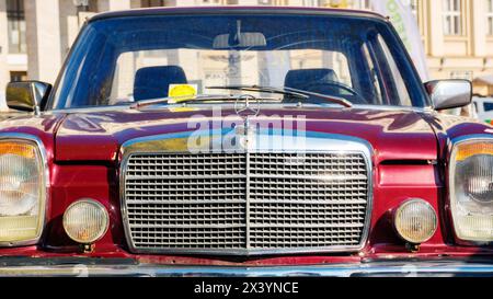uzhgorod, ukraine - 31 oct 2021: front view of a red  oldtimer mercedes w114. sunny outdoor in autumn park Stock Photo