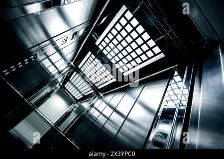 Modern steel metal elevator interior in an office building with artificial lights reflection Stock Photo