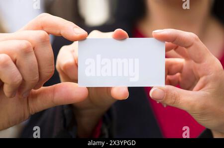 Three person holding a white card in his hand. You can put a text, message or logo on the empty surface. Stock Photo