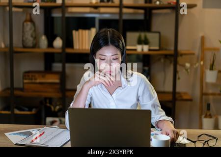 The young woman is working late into the night Stock Photo