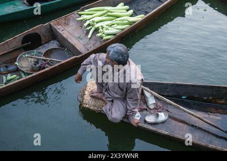 Floating market vendors enjoying a smoke, Dal Lake, Srinagar, Kashmir, India Stock Photo