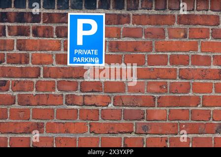 Private parking traffic sign on red brick wall Stock Photo