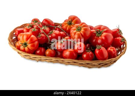 Red tomatoes of various types and shapes in wicker basket isolated on white with clipping path included. Tomatoes and cherry tomatoes Stock Photo
