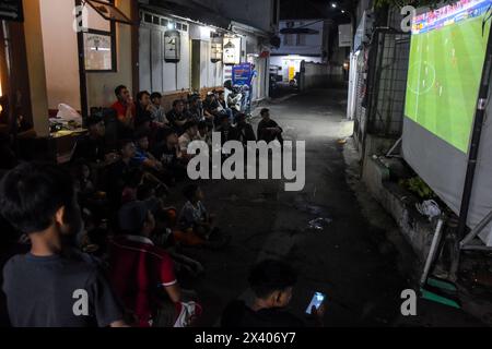 Bandung, West Java, Indonesia. 29th Apr, 2024. Indonesian football fans watch together the 2024 AFC Qatar U23 Asian Cup semifinal football match between Indonesia and Uzbekistan on the streets of Bandung. (Credit Image: © Dimas Rachmatsyah/ZUMA Press Wire) EDITORIAL USAGE ONLY! Not for Commercial USAGE! Stock Photo