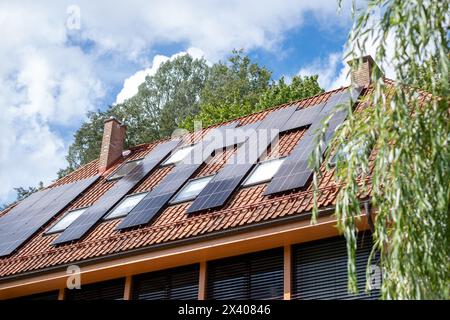 Photovoltaic panels atop a house illustrate the growing adoption of solar energy in urban settings, reflecting a move towards eco sustainability and s Stock Photo