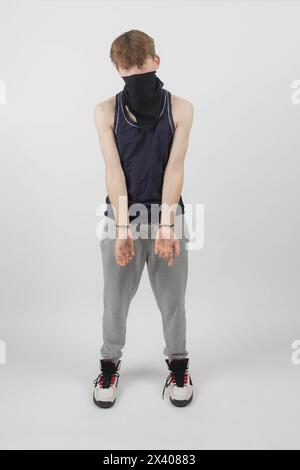 A Teenage Boy Wearing a Mask, Arrested in Handcuffs Stock Photo