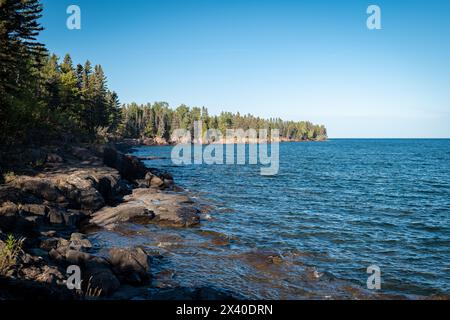 Gorgeous landscape along the rocky and tree lined north shore of Lake Superior in Minnesota, with blue water and sky on a beautiful sunny afternoon. G Stock Photo