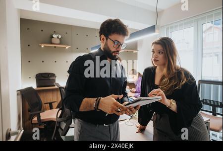 Business colleagues discussing project strategies with focused teamwork in a modern office Stock Photo