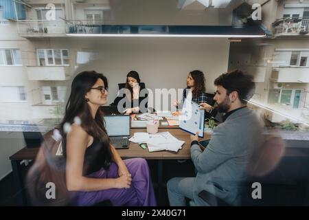 Diverse team collaborating on project in modern office space Stock Photo