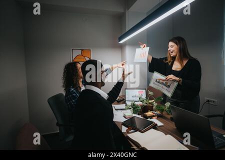 Multicultural team in modern office discussing growth and sales statistics Stock Photo
