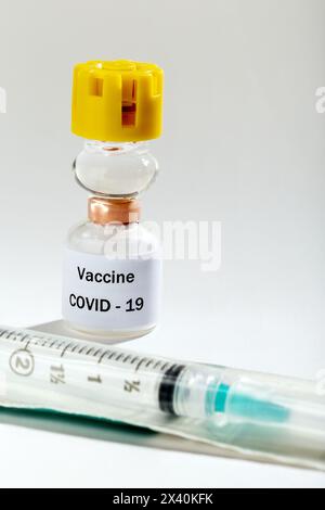 Medical Vaccine COVID-19 vial and syringe on a white background with spotlight effect; Studio Stock Photo