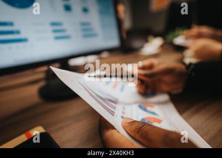 Multiracial team of young businesspeople analyzing project statistics in office Stock Photo