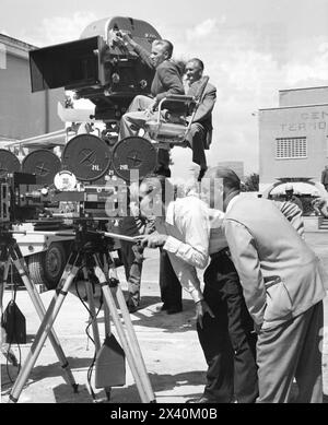 Cameraman ROBERT SURTEES  shows CHARLTON HESTON the new camera for the Camera 65 process at Cinecitta Studios in Rome during the making of  of BEN HUR 1959 Director WILLIAM WYLER  Music MIKLOS ROZSA Costume Design ELIZABETH HAFFENDEN Metro Goldwyn Mayer Stock Photo