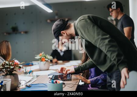 Creative team collaborating in bustling office environment, focus on technology and innovation Stock Photo