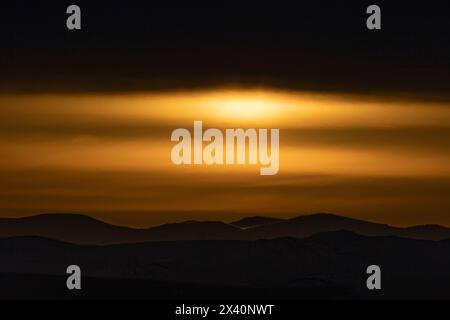 Sun burns through the fog and thick clouds north of Haines Junction, Yukon. Makes for a very moody and surreal image; Haines Junction, Yukon, Canada Stock Photo