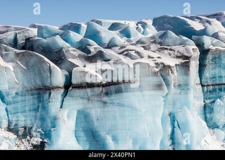 Blue ice formations on Knik glacier against a bright blue sky; Alaska, United States of America Stock Photo