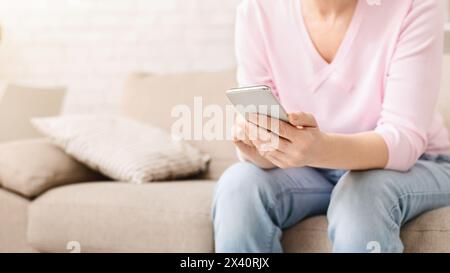 Cheerful aged woman using her smartphone at home Stock Photo