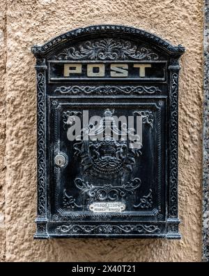 Post box in black metal with decorative designs in Alghero, Italy. Alghero is a city on the northwest coast of Sardinia, Italy. Encircled by ancien... Stock Photo