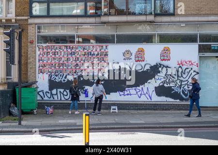 LONDON- MARCH, 30, 2024: Finchley Road, North West London- people putting up portrait posters of Isreal hostages taken by Hamas on October 7th. Stock Photo