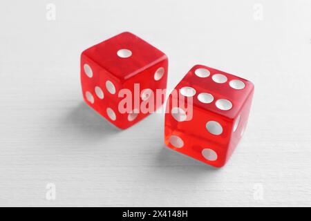 Two red game dices on white wooden table, closeup Stock Photo
