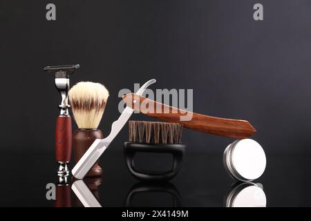 Moustache and beard styling tools on black mirror surface Stock Photo