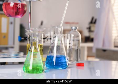 Laboratory analysis. Glassware with different liquids on white table indoors Stock Photo