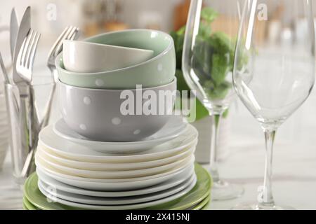 Many different clean dishware, glasses and cutlery on table indoors, closeup Stock Photo