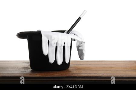 Magician's hat, gloves and wand on wooden table against white background Stock Photo