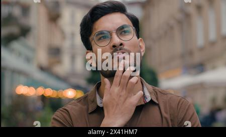Close up thoughtful confused puzzled Indian Arabian ethnic male man student businessman guy deeply thoughts pondering thinking business solution idea Stock Photo