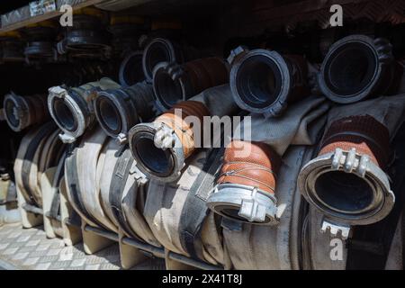 Rolled fire hoses in firetruck. Stock Photo