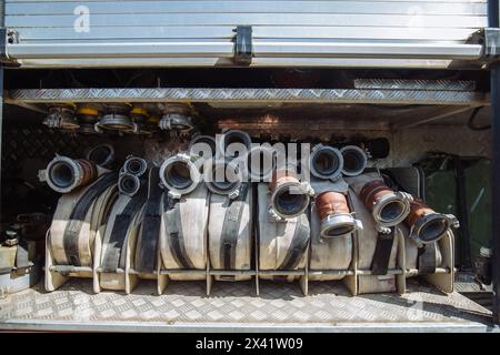 Rolled fire hoses in firetruck. Stock Photo