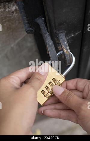 padlock with code, hands of a person placing key with numbers, details of security object, wallpaper Stock Photo