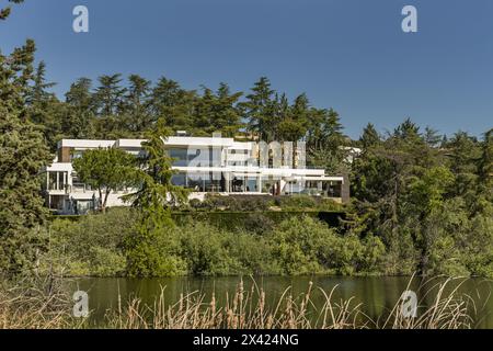 a beautiful modern style mansion house surrounded by trees on the shore of a lake Stock Photo