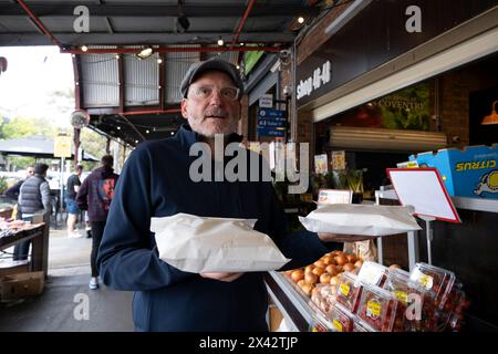 A man shopping at the South Melbourne market. The market is an inner city landmark and favorite of tourists. South Melbourne, Victoria, Australia. Stock Photo