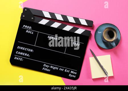 Movie clapper, coffee, paper notes and pen on color background, flat lay Stock Photo