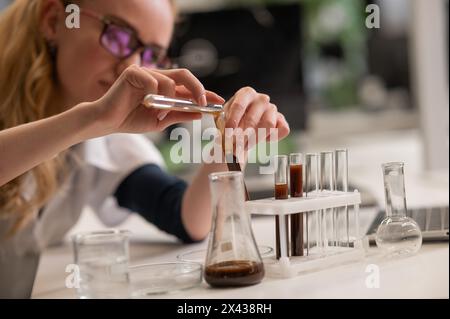 Caucasian woman in a medical gown doing laboratory experiments.  Stock Photo