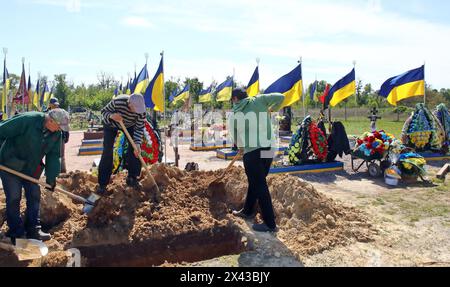 Non Exclusive: HOSTOMEL, UKRAINE - APRIL 29, 2024 - Gravediggers work at the Alley of Heroes at the Hostomel Cemetery, Hostomel, Kyiv region, northern Stock Photo