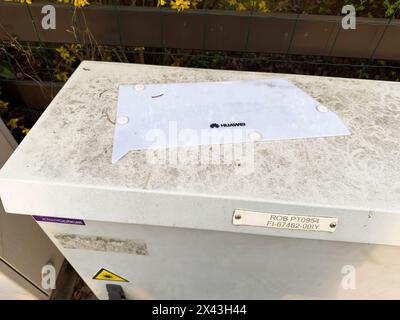 Paris, France - Mar 8, 2024: Huawei outdoor unit for telecommunications, mounted and operational, with identifying tags and labels on a optic fiber distributor point in France - Ideaoptical Stock Photo