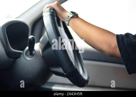Closeup image of male driver hands holding steering wheel. Stock Photo